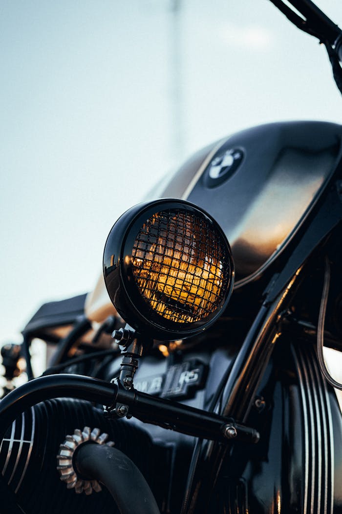 embark Close-up of a vintage motorcycle headlight with a glazed finish during sunset.